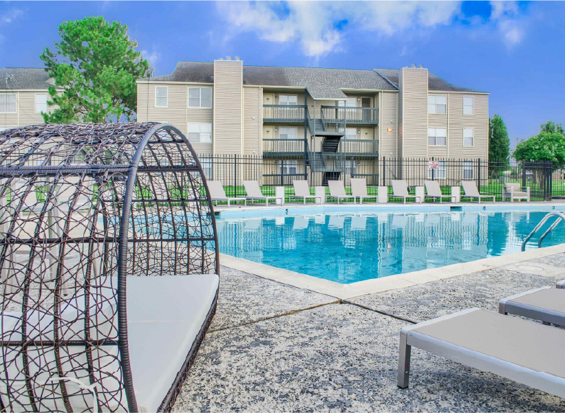 Resort-style pool with lounge chairs at Riviere Royale apartments in New Orleans East